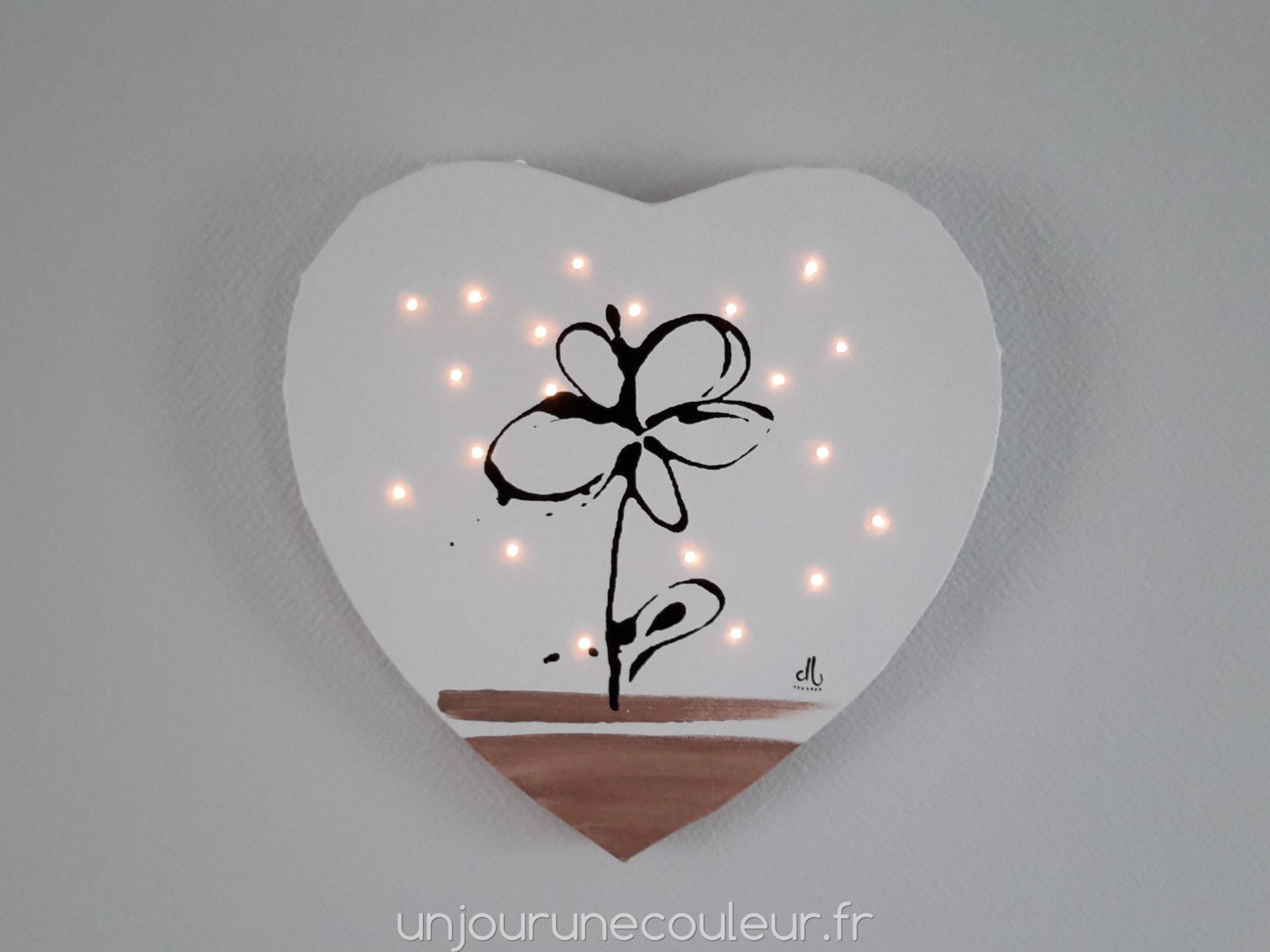 Tableau lumineux en forme de coeur : fleur noire sur fond blanc