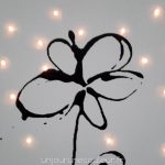 Fleur noire sur tableau lumineux