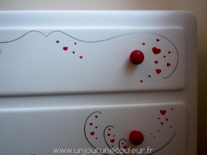 Des nuées de coeurs roses peints à la main sur une commode blanche