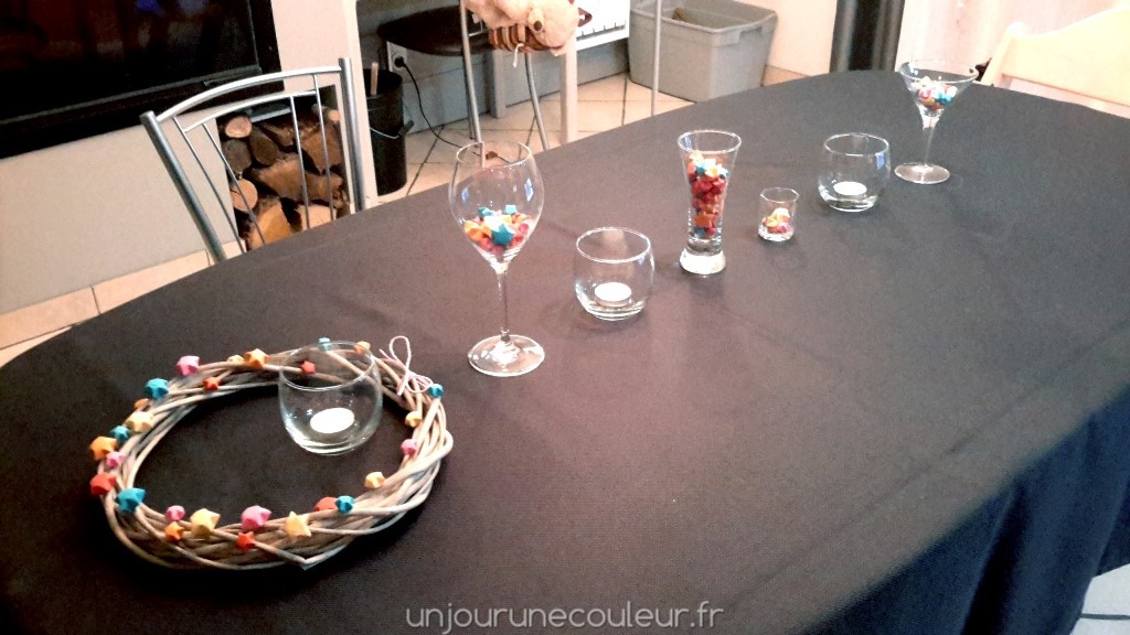 Décoration de table bougies et étoiles colorées dans des verres