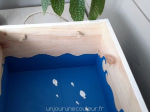 Des vagues peintes dans une caisse en bois